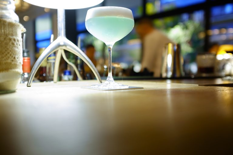 Hellblauer Cocktail mit Schaumkrone auf dem Tresen der il Bar in Konstanz
