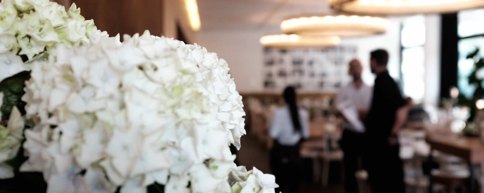 Weiße Hortensien und Service-Team im Restaurant il Boccone Konstanz