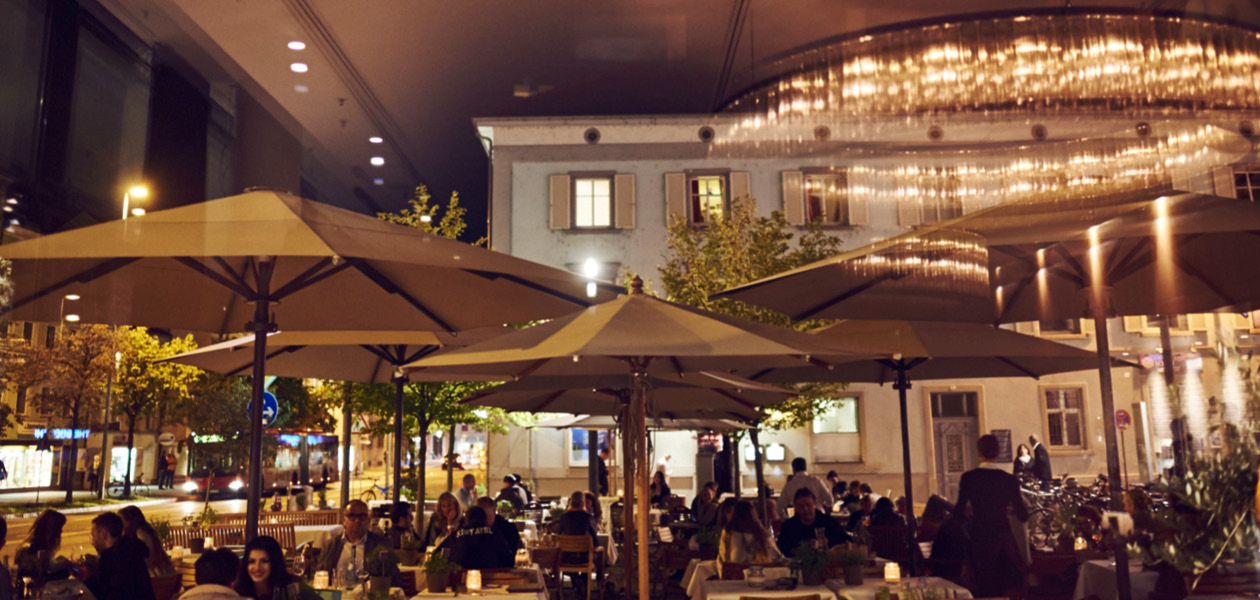Gäste auf der beleuchteten Terrasse des il Boccone am Abend in Konstanz